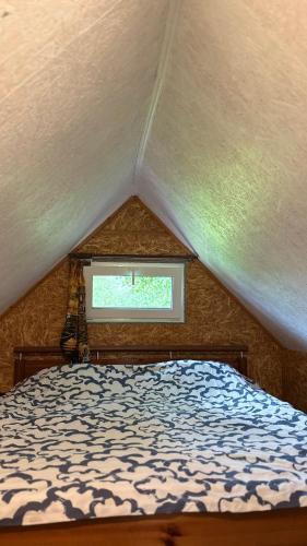 a bed in a room with a window at Ziedi in Ieriķi