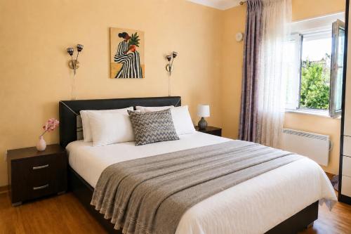 a bedroom with a large bed and a window at SUNLUX Seaview Apartment in Đenovići