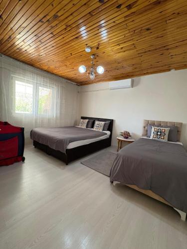a bedroom with two beds and a wooden ceiling at HAPPY HOUSE 1 Pamukkale in Pamukkale