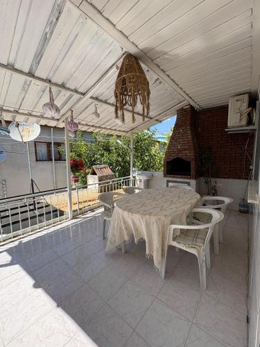 a patio with a table and chairs under a roof at HAPPY HOUSE 1 Pamukkale in Pamukkale