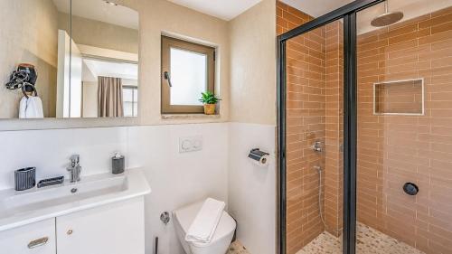 a bathroom with a shower and a toilet and a sink at Luz Suites in Kaş