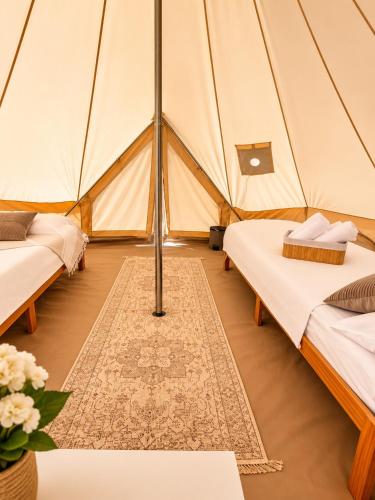 a tent with two beds in a room at Bulamac Luxury Glamping in Vama Veche