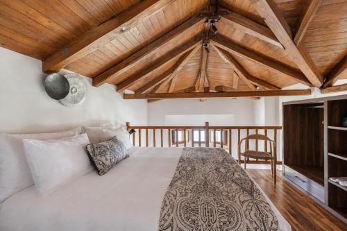 a bedroom with a bed and a wooden ceiling at Tilia Resort in Mouresi