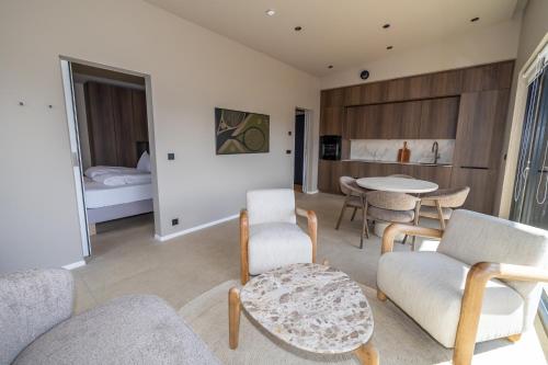 a living room with a couch and chairs and a bed at North Mountain View Suites in Akureyri