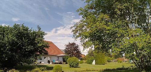 a white house with a red roof and some trees at Ferienhaus Ringelwiese in Schönstedt
