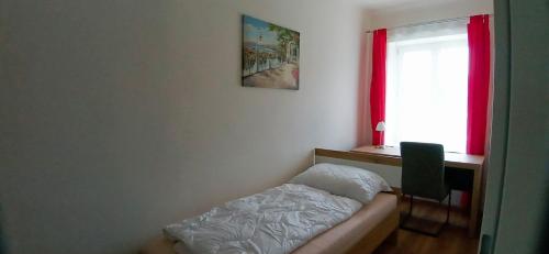 a bedroom with a bed and a desk and a window at Fridolins Family Apartment - Ferienwohnung im Südburgenland in Markt Allhau
