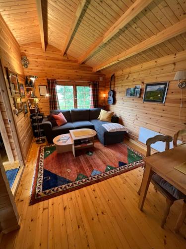 a living room with a couch and a table at Nordlands hytta in Meby
