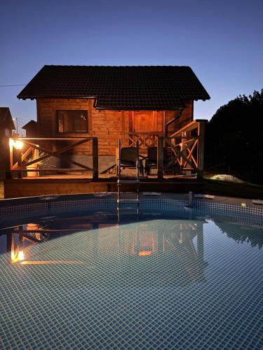 a large swimming pool in front of a house at Brvnara Beli in Gornji Milanovac