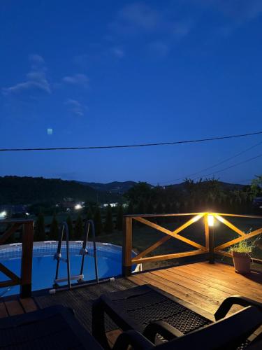 a deck with a view of a pool at night at Brvnara Beli in Gornji Milanovac