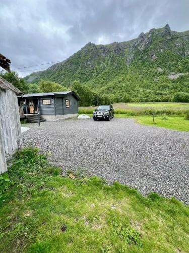 a car parked in front of a house with a mountain at Nordlands hytta in Meby