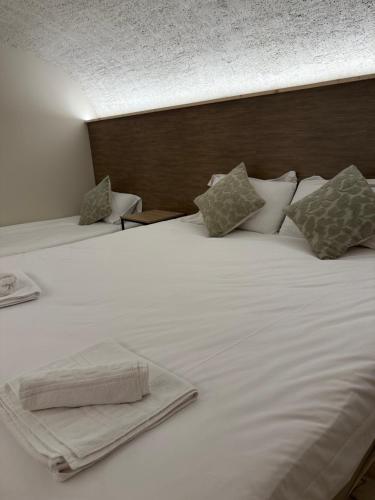 a bed with white sheets and pillows on it at Le Col Getaway Virage 1 in Le Bourg-dʼOisans