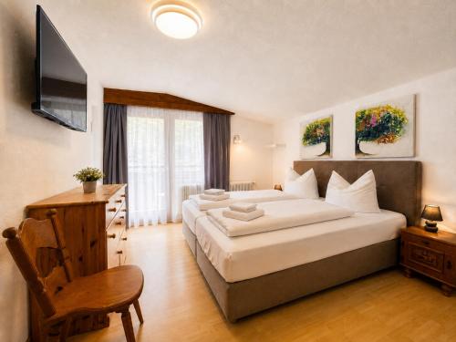 a bedroom with a large bed and a television at Hotel Kajetansbrücke in Pfunds