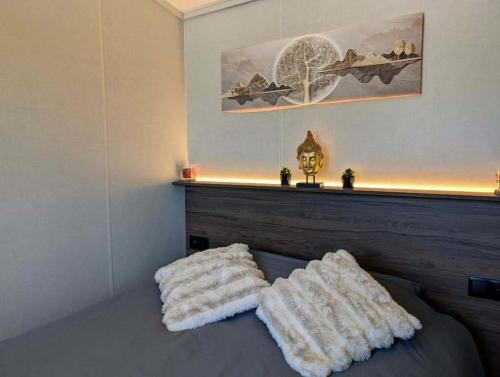 a bedroom with a bed with two pillows on it at Tiny house climatisé et jacuzzi privatif in Saint-Loup-Nantouard