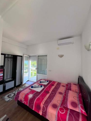 a bedroom with a bed with a red comforter at Krapce - Lake View Apartments in Star Dojran