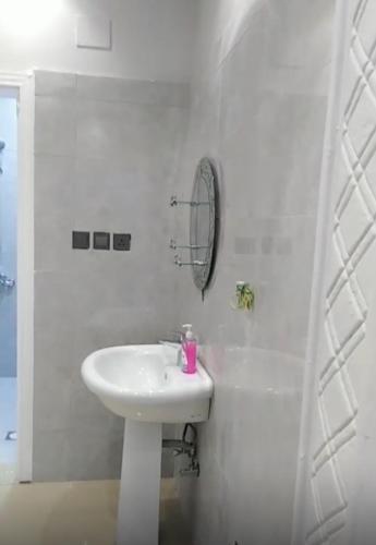 a white bathroom with a sink and a mirror at شقق النخبة The Elite department in As Sayl aş Şaghīr