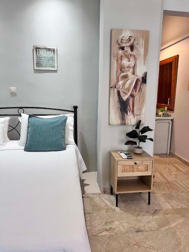 a bedroom with a bed and a painting on the wall at Studios Μιχαλαρεα in Kyparissia