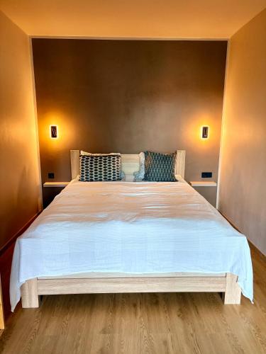 a bedroom with a large white bed with blue pillows at Freshly Renovated Black & Sand Studio in Liepāja