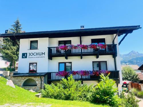 a building with flowers on a balcony at Jochum Hotel Garni in Fiss