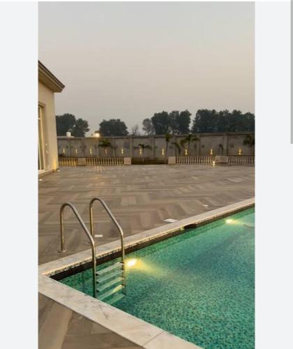 a swimming pool in the middle of a courtyard at The corbett story in Rāmnagar