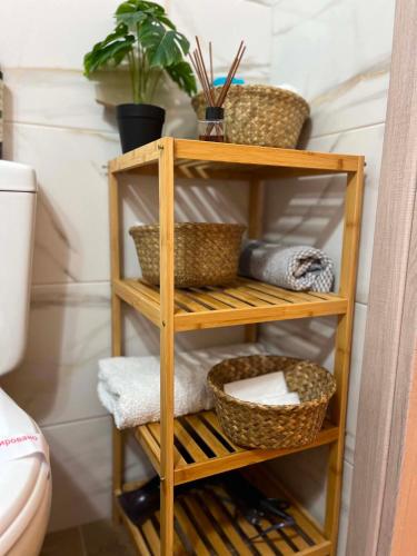 a wooden shelf with baskets and plants in a bathroom at Studios Μιχαλαρεα in Kyparissia