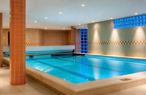 a large swimming pool with blue water at Paping Hotel & Spa - Rest Vonck by Flow in Ommen