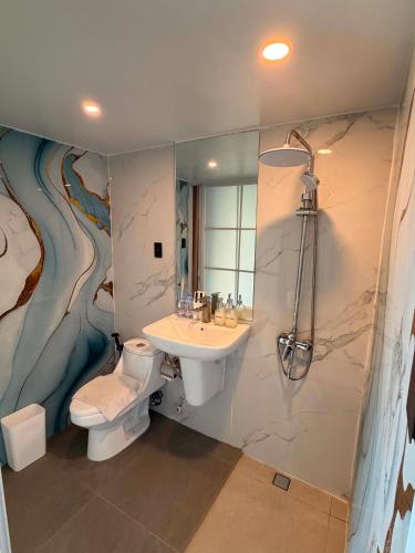 a bathroom with a sink and a toilet and a shower at The South Hideaway Oslob in Gawi
