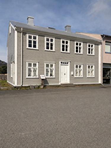 a gray house with white windows and a driveway at Cozy Home with Breathtaking Mountains and Sea Views in Flateyri