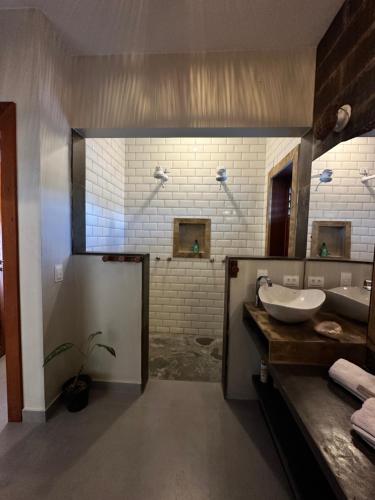 a bathroom with two sinks and a large mirror at Refúgio prea in Cruz