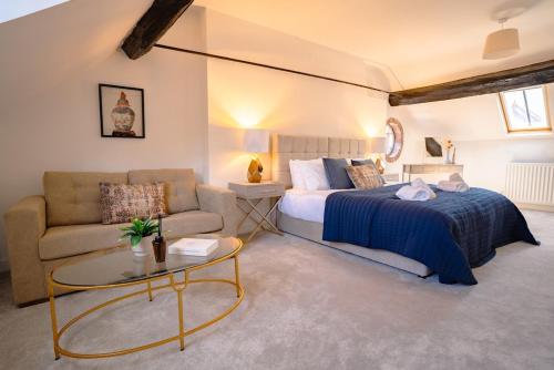 a bedroom with a bed and a couch and a table at St James House Timeless Comfort Central Congleton in Congleton