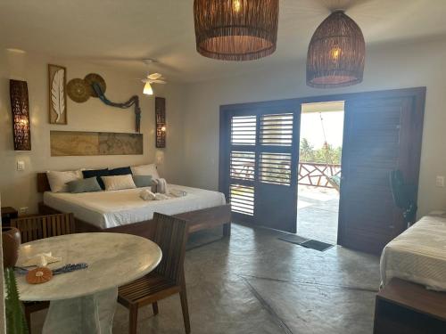 a bedroom with two beds and a table and a patio at Refúgio prea in Cruz