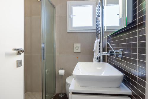 a bathroom with a sink and a glass shower at Luxury 2BR Limassol Marina Views in Limassol