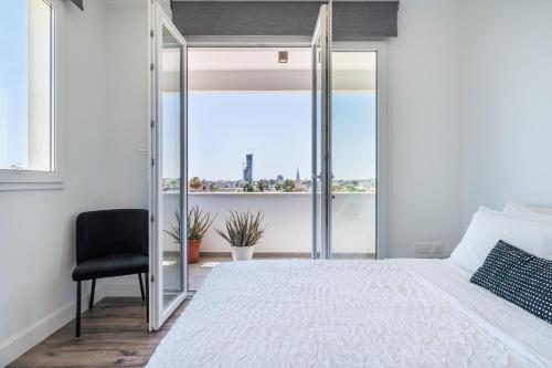 a bedroom with a large bed and a chair at Luxury 2BR Limassol Marina Views in Limassol