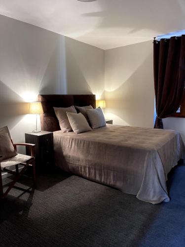 a bedroom with a large bed and a chair at Appartement Moutiers Centre in Moutiers