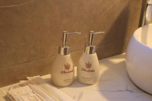 two bottles of soap sitting on a bathroom counter at D'la Lento Hotel in Hanoi
