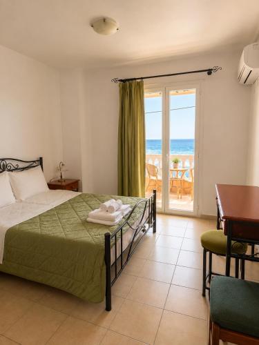 a bedroom with a bed and a view of the ocean at Marialena hotel in Archangelos