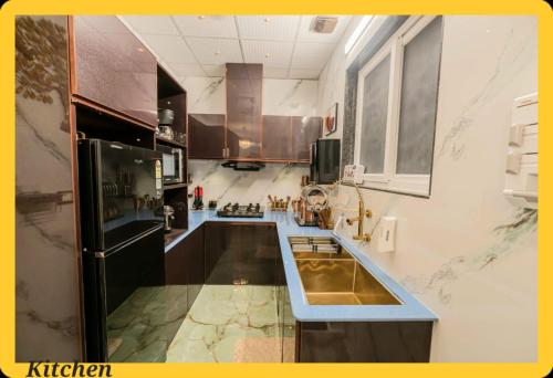 a large kitchen with a sink and a refrigerator at UDUPI HOMESTAY CHALET LA BONNE Vie in Udupi