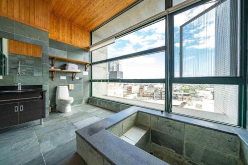 a bathroom with a large sink and a large window at 元本山明水秀行館 in Jiaoxi