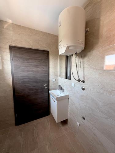 a bathroom with a black door and a sink at Vila Šarić in Doglodi