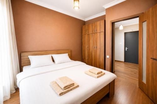 a bedroom with a bed with two towels on it at Home Inn Apartments Your house Jikia-Central Tbilisi in Tbilisi City
