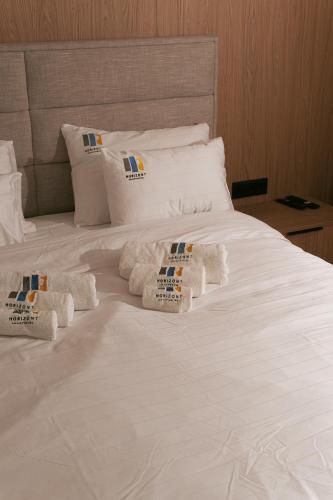 a white bed with white pillows and towels on it at Horizont Aparthotel Jahorina in Jahorina