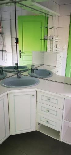 a bathroom with two sinks and a large mirror at La ferme du lac Saint Front in Saint-Front