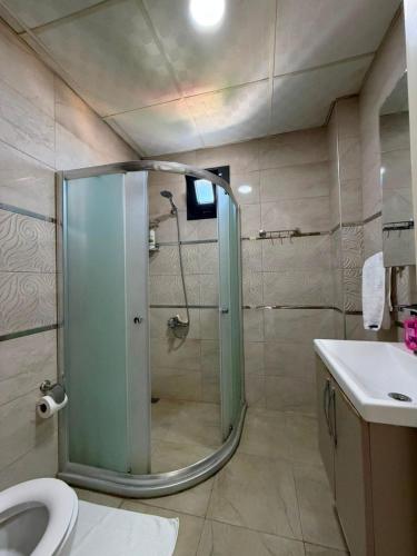 a bathroom with a shower and a toilet and a sink at Han Suite Ev-Otel Mersin in Kaleköy