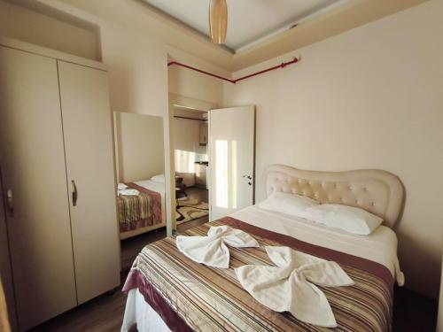 a bedroom with a bed with a robe on it at Han Suite Ev-Otel Mersin in Kaleköy