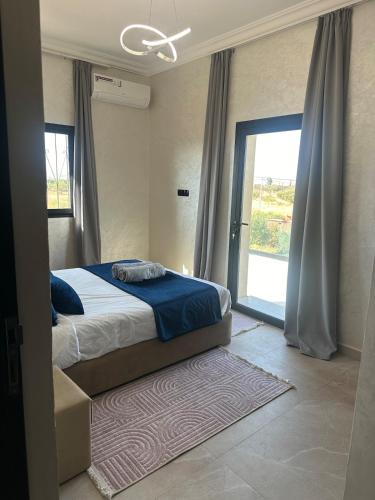 a bedroom with a bed and a sliding glass door at Villa with pool, ping pong table, trampoline in Mellah Bakka