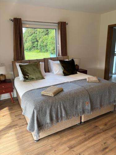 a large bed in a room with a large window at Chameleon House in Dornoch
