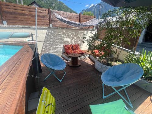 a deck with two chairs and a table next to a pool at Mazot en Abondance in Vacheresse