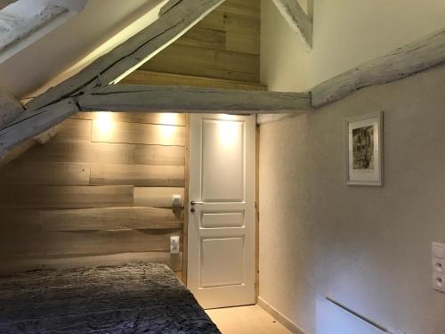 een slaapkamer met een bed en een houten muur bij L'envie d'ailleurs in Honfleur