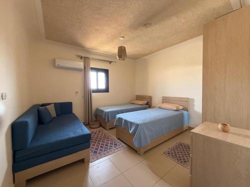 a bedroom with two beds and a couch and a chair at Art Home - La Hacienda, Ras Sudr in Ras Sedr