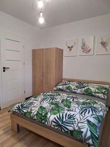 ein Schlafzimmer mit einem Bett mit einer grün-weißen Bettdecke in der Unterkunft Czarwoli in Wola Bokrzycka