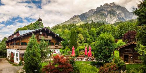 a house in a forest with mountains in the background at Ferienhof Millinghof in Leogang